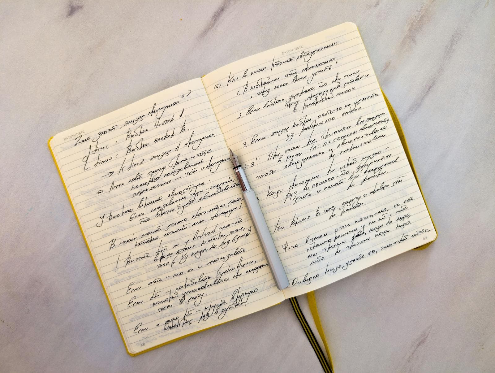 Open notebook with handwritten notes and a pen resting across it, suggesting pre-call planning by hand.